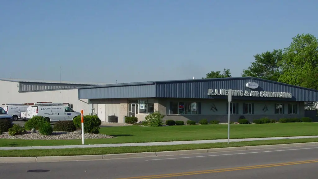 The R.A. Heating & Air Conditioning building on Water Street by day, service vans in the lot